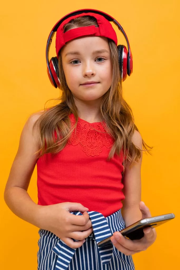 cute-charming-young-girl-with-red-headphones-on-a-yellow-wall.jpg